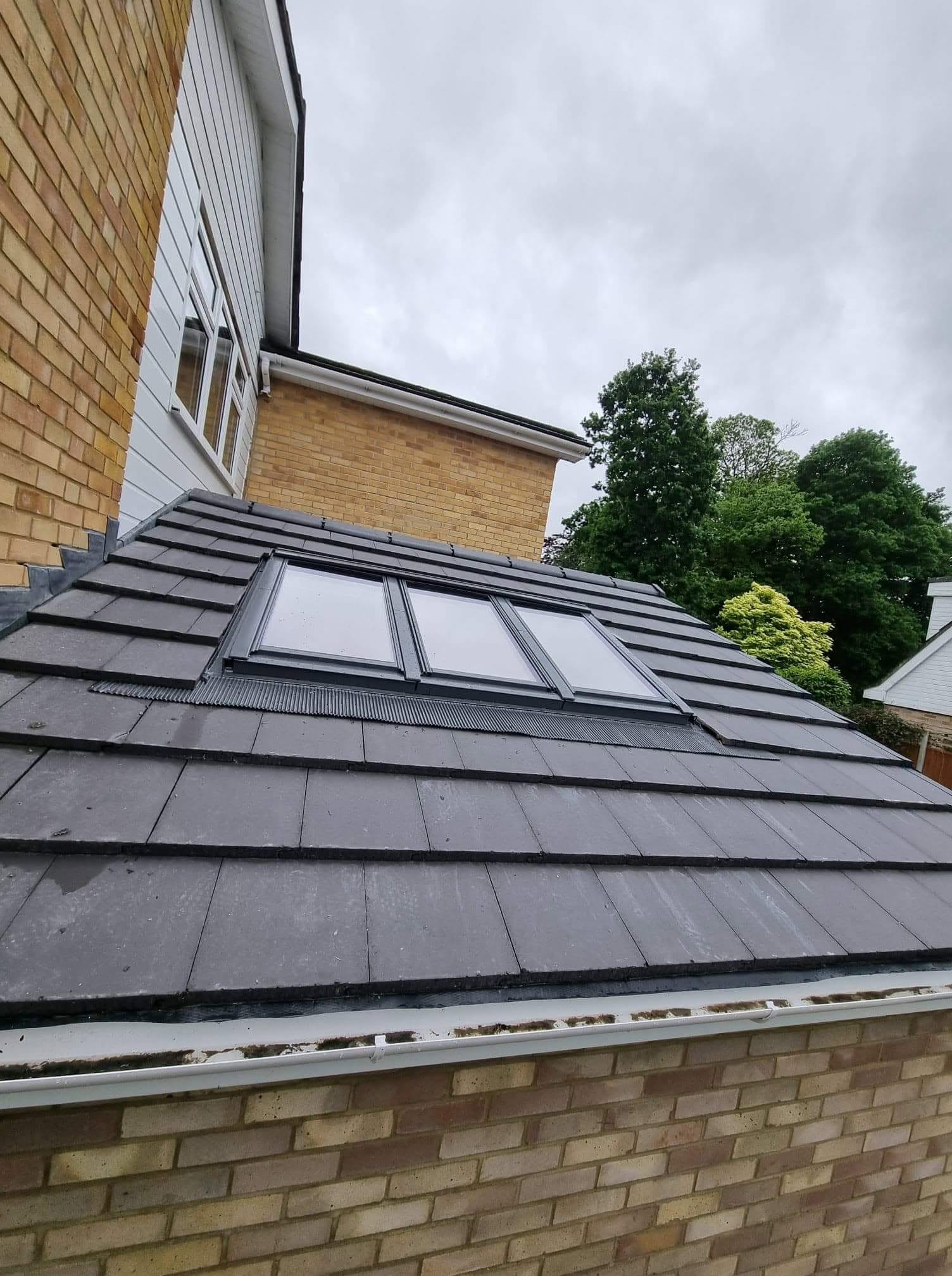 Triple bank of Velux windows fitted in a slate-tiled extension roof by Shoreside Roofing